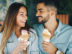 Happy young couple having date and eating ice cream