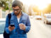 Outdoor portrait of modern young man with mobile phone in the street.